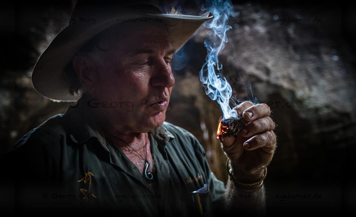 Sab Lord zündet ein von Termiten bearbeitetes Stück Holz an. Ein altes „Hausmittel“ der Aborigines, um mit dem Rauch die Mücken zu vertreiben / © Foto: Georg Berg