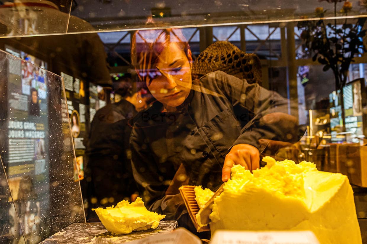 Blick durch die Arbeitstheke im Maison du Beurre. Aus einem Butterblock werden kleine Portionen abgeteilt / © Foto: Georg Berg