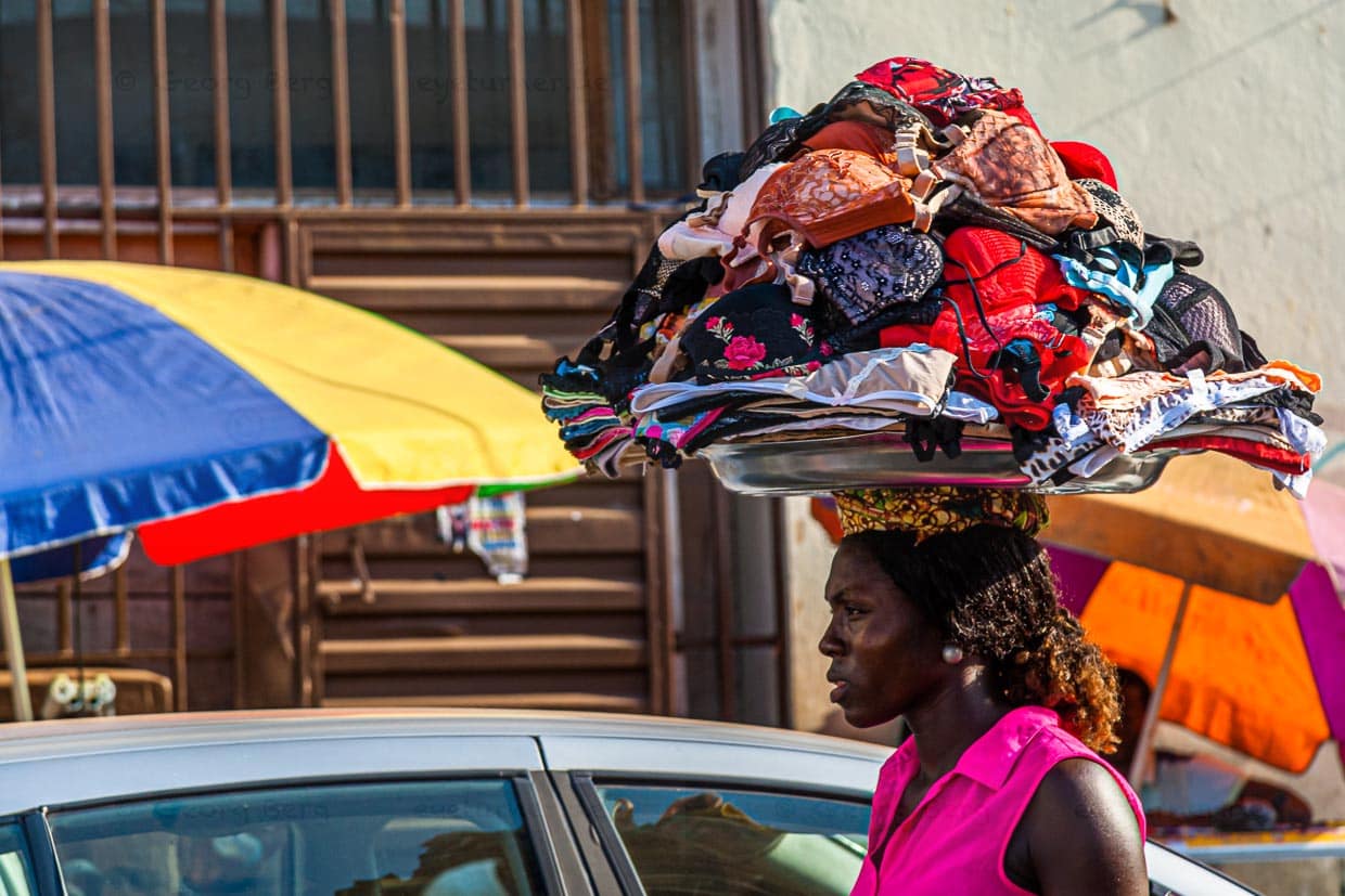 Frau trägt ein Tablett voller BHs auf dem Kopf / © Foto: Georg Berg