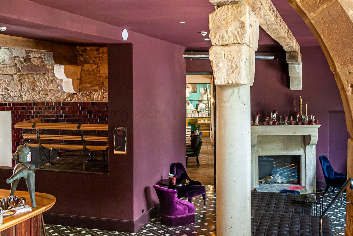 Blick in die Tiefe: Wer in das Restaurant oder an die Bar möchte, kommt durch die Lounge und gleich in Stimmung. Ein mutiger Stilmix von Farben, Möbeln und Fliesen immer mit dem Charme des alten Gesteins als Kontrast / © Foto: Georg Berg