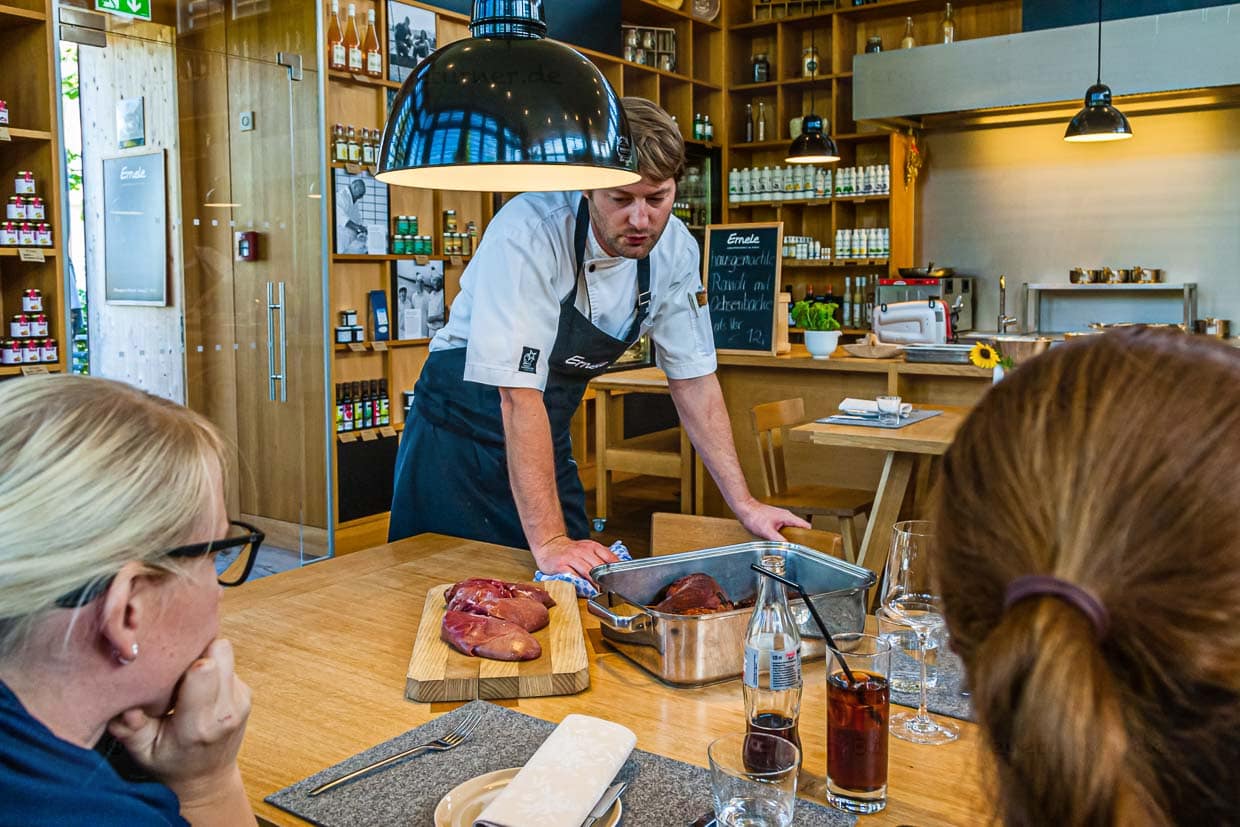 Küchenchef Felix Groß im Beratungsgespräch mit Gästen am Tisch / © Foto: Georg Berg