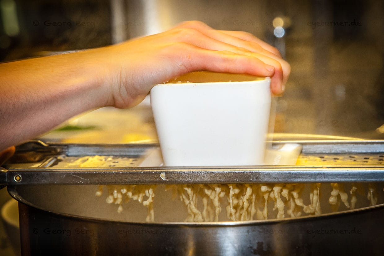 Der Knöpfler im Einsatz. Kässpätzler werden auch Käsknöpfle genannt / © Foto: Georg Berg