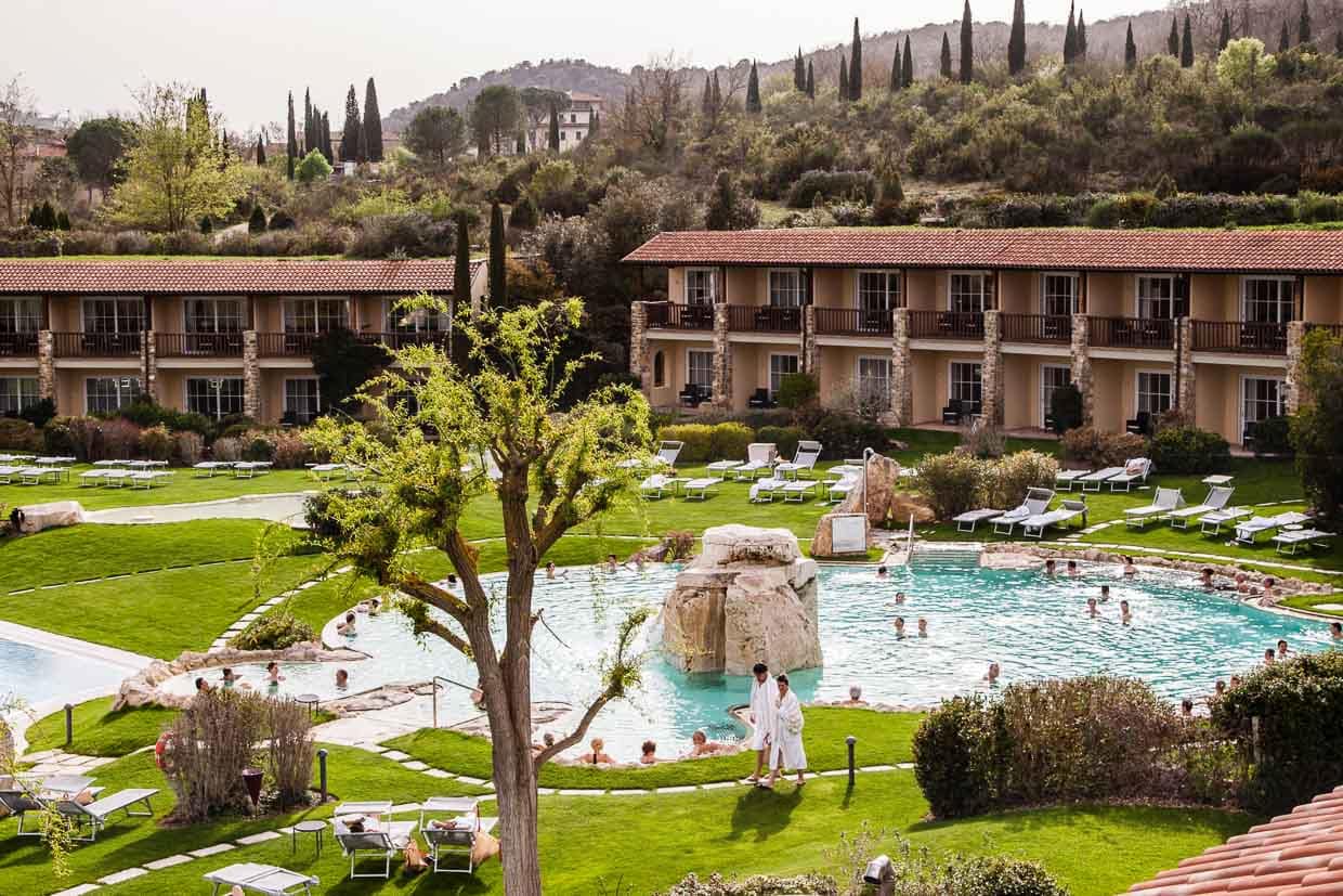 Beides sehr verlockend: Die Thermalwelt mit mehreren Außenbecken und jenseits der harmonisch eingefügten Trakte mit den Gästezimmern, die Hügel und Zypressenlandschaft des Val d’Orcia / © Foto: Georg Berg