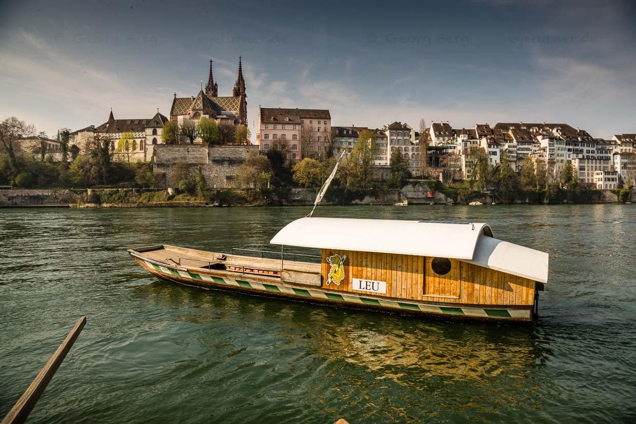 Die Basler Rheinfähre „Leu“ am Münster. In den Mittagsstunden fahren die Menschen gerne zum Mittagessen auf die andere Seite, die dann in der Sonne liegt. Eine Überfahrt kostet 1,60 Franken oder Euro / © Foto: Georg Berg