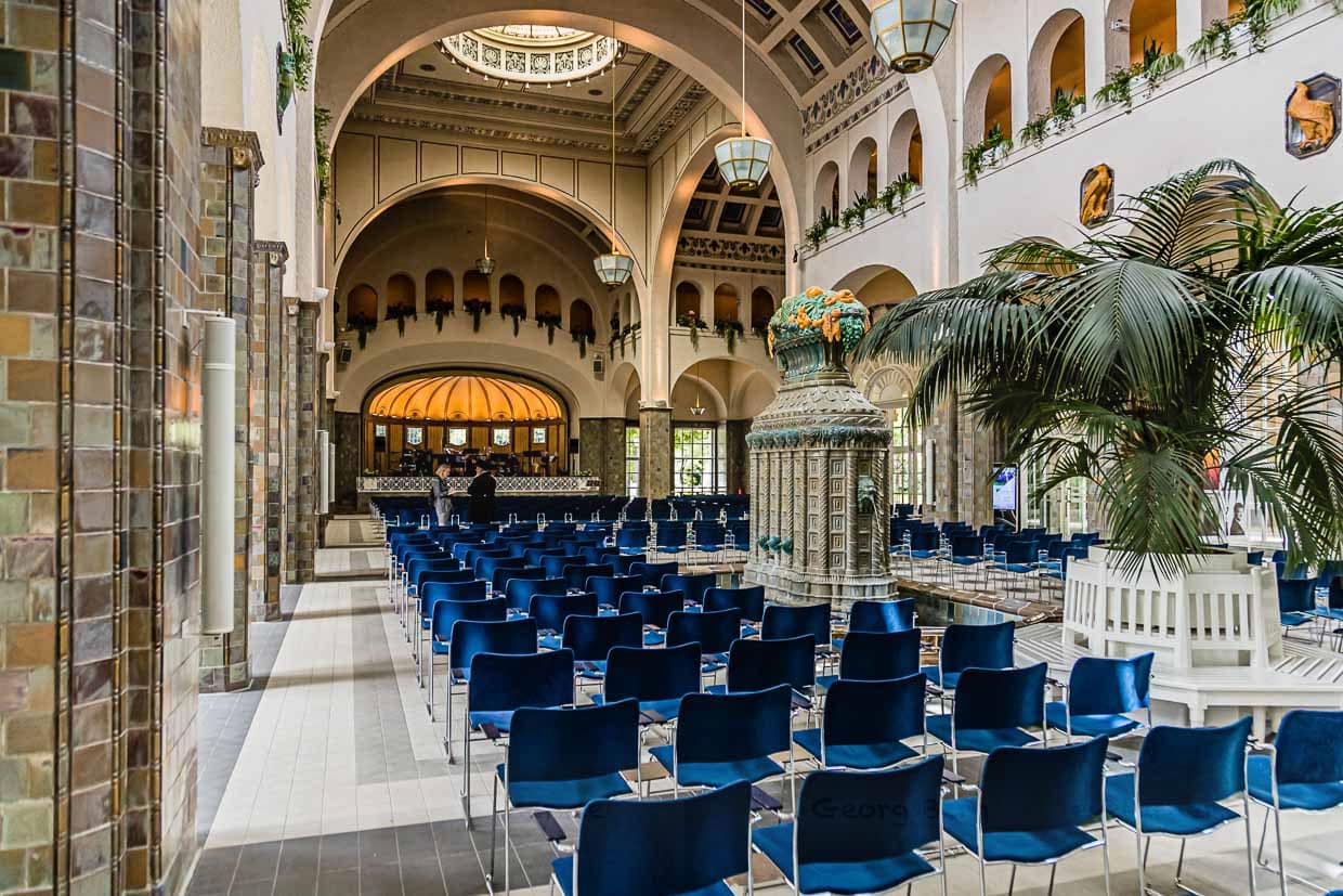 Die größte Wandelhalle Europas wurde 1912 vom Architekten Max Littmann erbaut. Zwischen den Säulen können Kurgäste noch heute entspannt schlendern. Die wunderschönen Fliesen an den Säulen sind von Villeroy & Boch / © Foto: Georg Berg