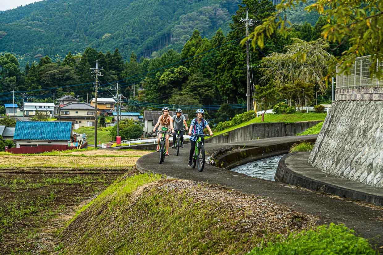 Mit dem Rad unterwegs, vorbei an Bewässerungskanälen für die Felder, auf denen Reis und Buchweizen wächst. Japaner nennen diese Landschaft zwischen Berg und Acker Satoyama / © Foto: Georg Berg