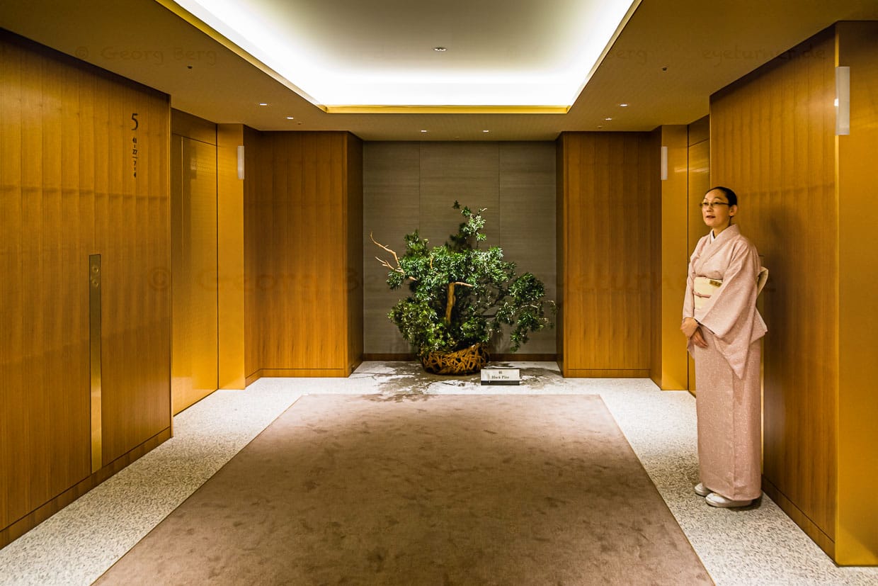 Hüterin der Aufzüge – ein Service im Kimono, den es schon seit den 1960er Jahren gibt. Aus der Lobby geht es in die Höhe. Ab Stockwerk 28 beginnen im Okura Prestige Tower die Gästezimmer / © Foto: Georg Berg