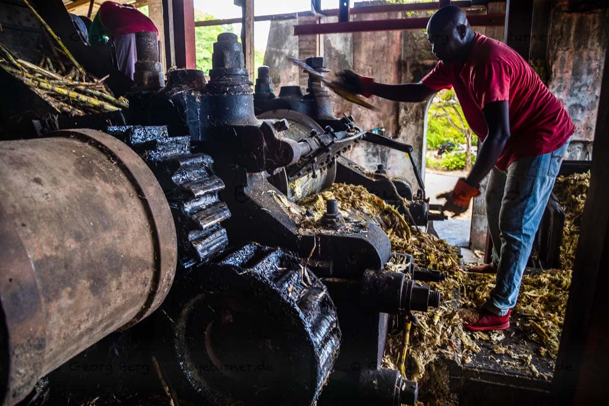 Im laufenden Betrieb werden einzelne Zuckerrohrstücke ein zweites Mal durch die Presse geschickt. Kaum zu glauben, dass diese Maschine schon zu Goethes Zeiten zuverlässig gearbeitet hat / © Foto: Georg Berg