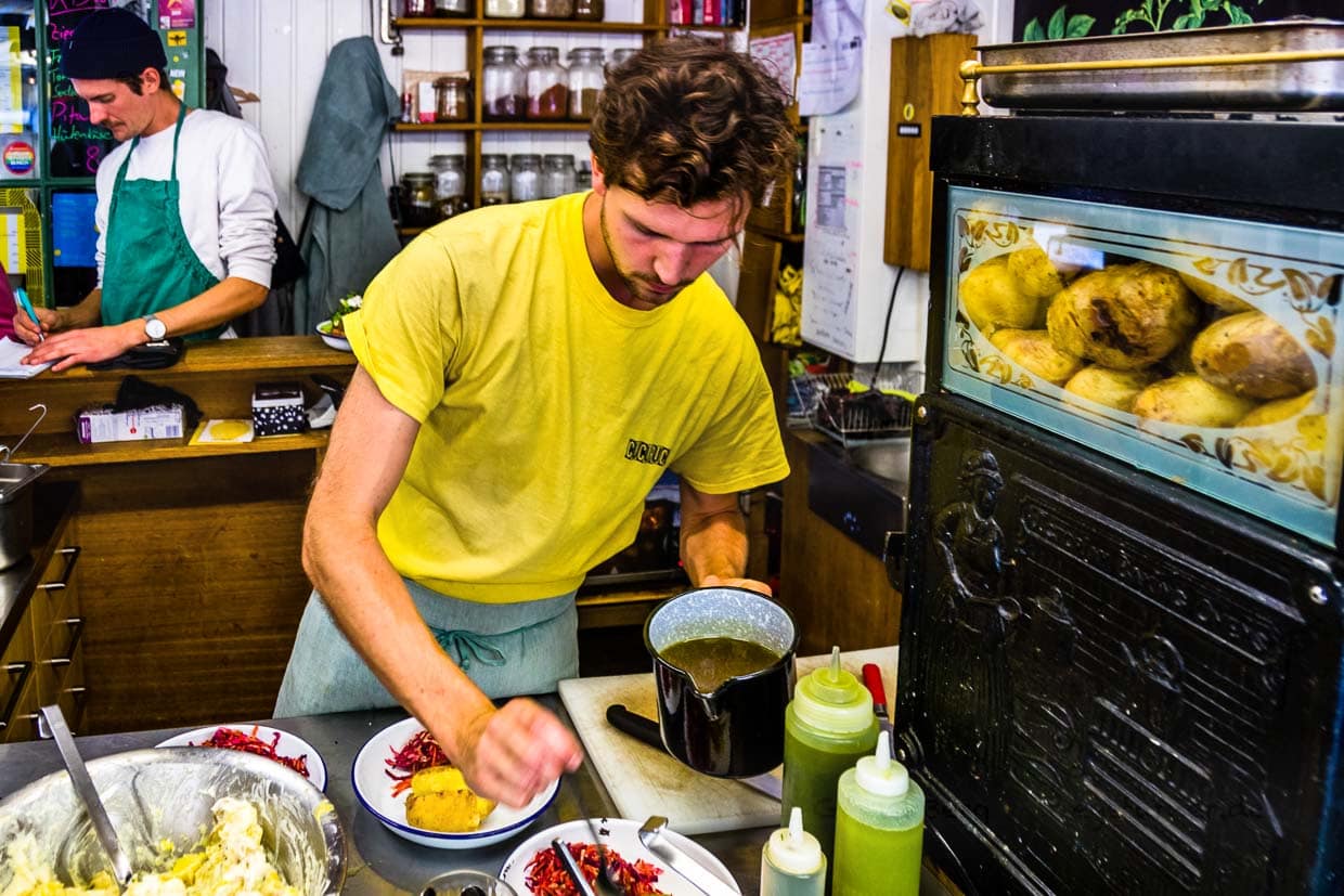 Bei Caspar Plautz entfaltet sich Kreativität auf engstem Raum. Im Ofen garen die Kartoffeln der Sorte Agria, Dominik Klier bereitet die Bestellungen vor. Als Beilage ein Rohkostsalat mit Bio-Gemüsen vom Nachbarstand Trübenecker / © Foto: Georg Berg