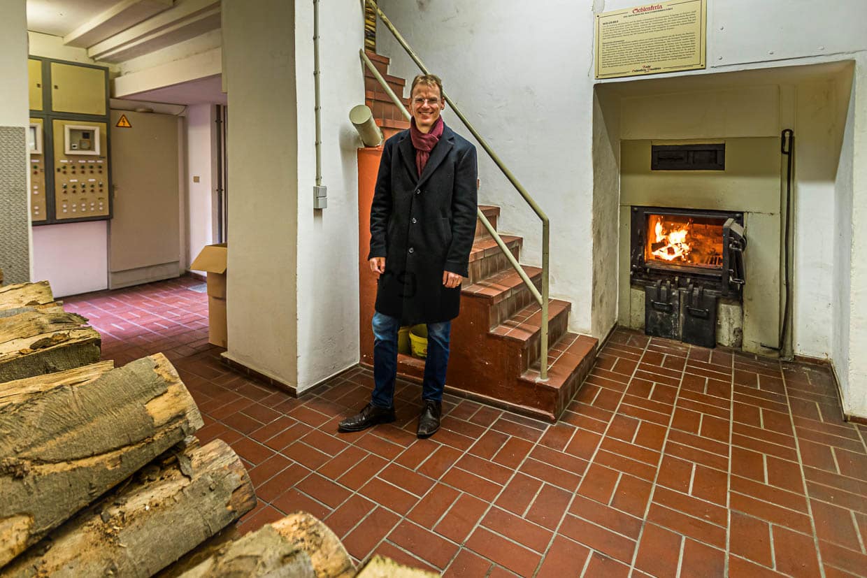 Matthias Trum, Inhaber der Heller Brauerei Schlenkerla vor dem offenen Feuer der Rauchdarre / © Foto: Georg Berg