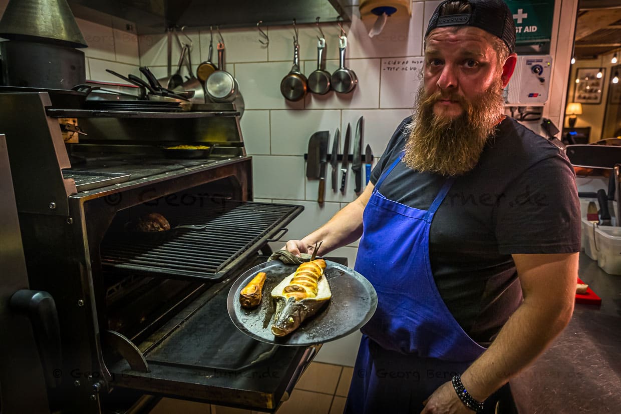 Cyril Aveline in der offenen Küche seines Yachthafen Restaurants Hestia. Im Mittelpunkt ein imposanter Jospergrill / © Foto: Georg Berg