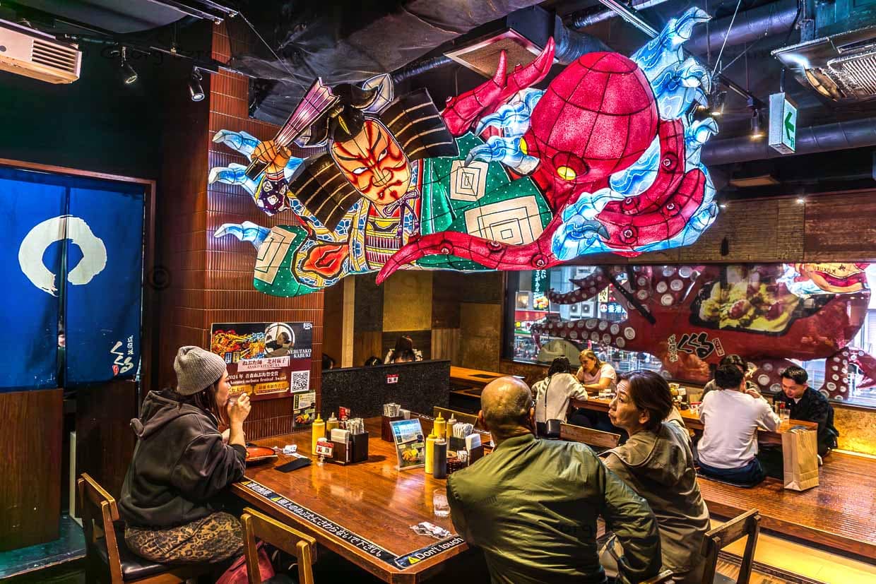 Takoyaki Restaurant auf Osakas Ausgehmeile Dotonbori. Die Spezialität sind Takoyaki = Oktopusbällchen, die man als Streetfood oder in Restaurants essen kann. Takoyaki wurde in den 1930er Jahren vom Straßenverkäufer Endo Tomekichi erfunden / © Foto: Georg Berg