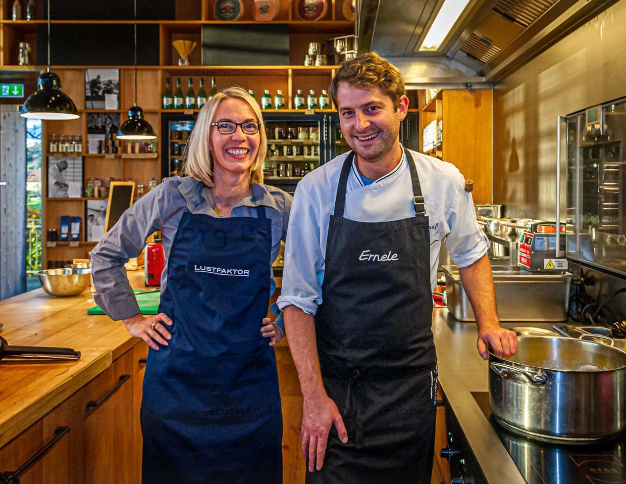 Koch Felix Groß in der offenen Küche des Ernerle mit Redakteurin Angela Berg. Im Hintergrund Regale voll mit regionalen Spezialitäten / © Foto: Georg Berg