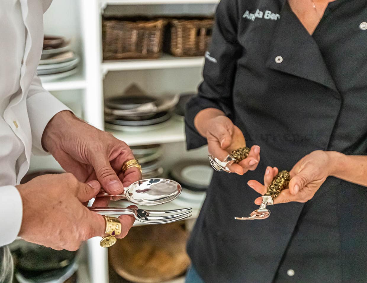 Produktion eines Kochbuchs von der Küche bis zum Fotoatelier. Bui Vössing zeigt Redakteurin Angela Berg welche oppulente Auswahl an Besteck und Porzellan er für die Produktion des Kochbuches hat. Hier edles Tafelsilber, das der Esskulturspezialist Franzen aus Düsseldorf beisteuert / © Foto: Georg Berg