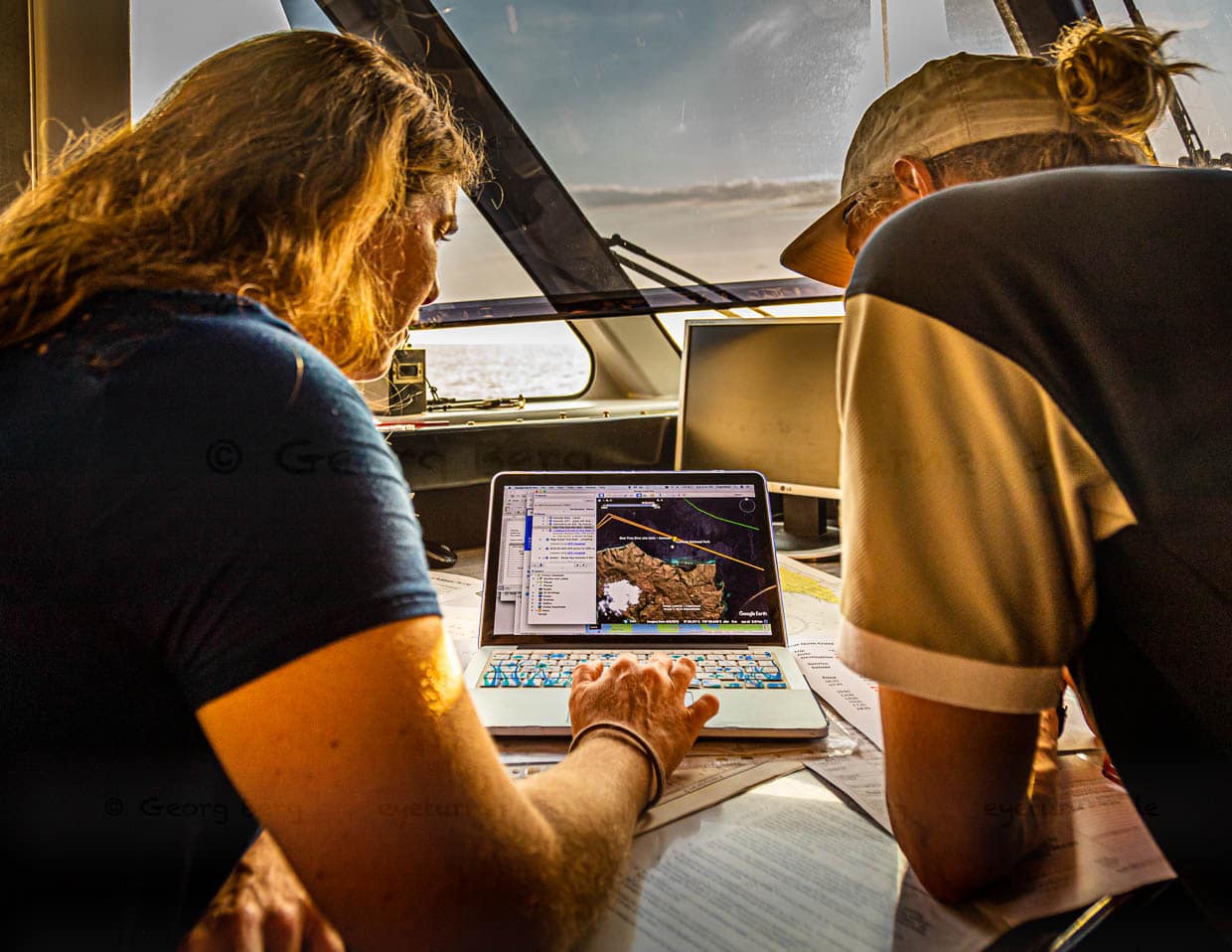 Angela und Jeremy planen auf der Brücke der True North anhand von Seekarten und Online-Informationen die Tauchgänge des nächsten Tages / © Foto: Georg Berg