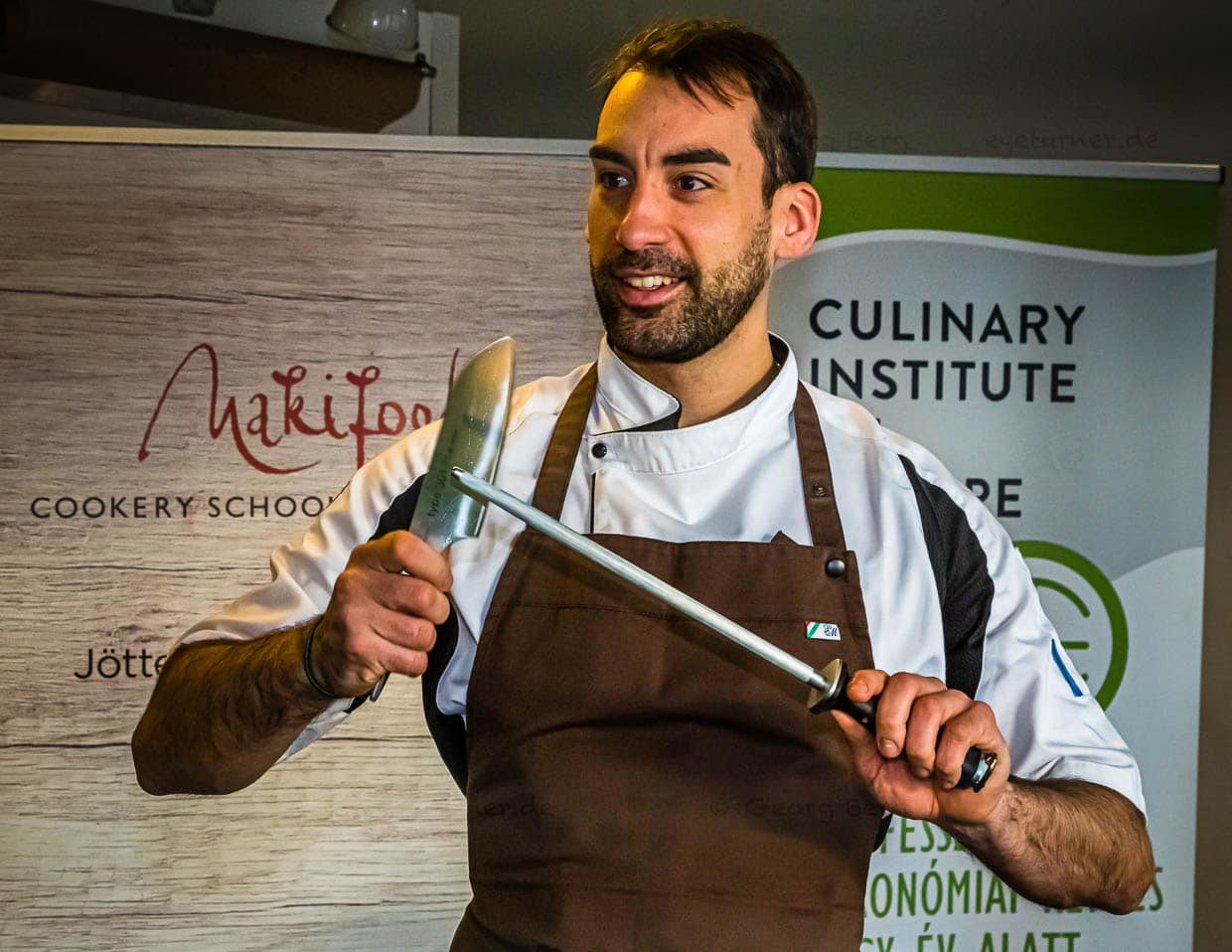 László Papdi macht das Kochmesser fit für die erste Schnittübung. Es wartet der Klassiker: die Zwiebel. Ob das Schneiden einen Zwiebel tränenreich oder tränenfrei verläuft, hängt ganz entscheidend von der Schnitttechnik und der Schärfe eines Messers ab / © Foto: Georg Berg