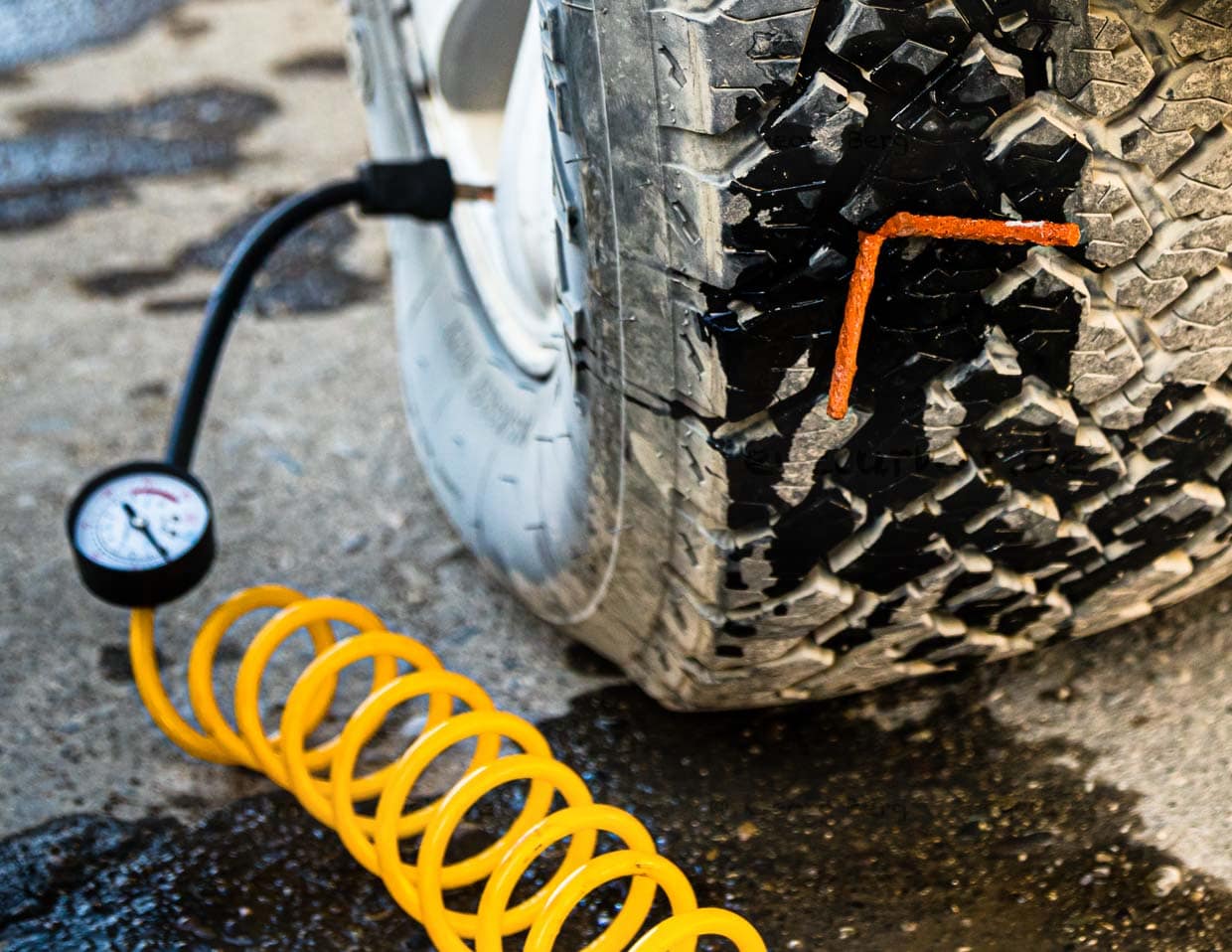 Während der ganzen Operation bleibt der Reifen am Auto und ein an die Batterie angeschlossener Kompressor sorgt für ein Mindestmaß an Druck / © Foto: Georg Berg