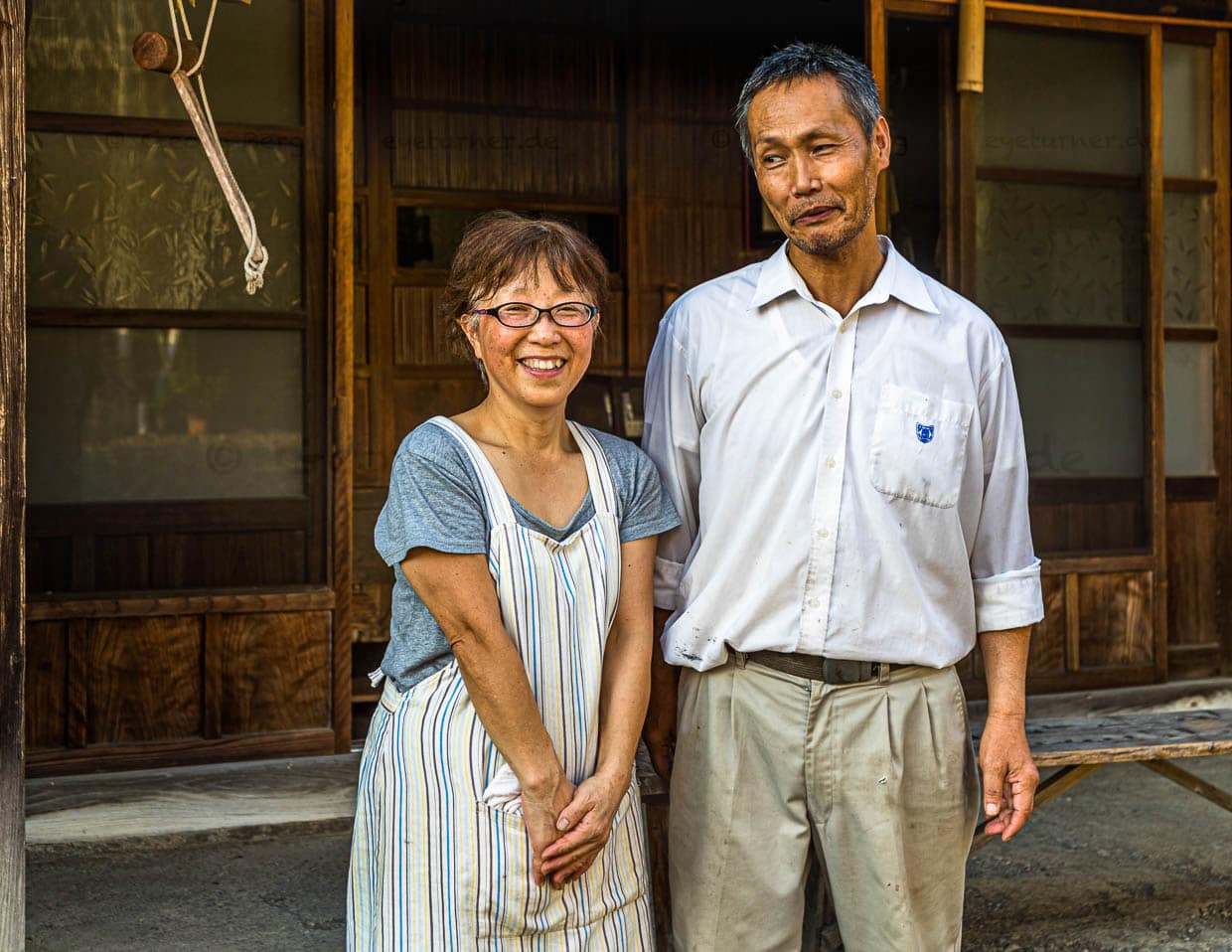 Das Ehepaar Uchino vor ihrer Farm. Der Sohn der Teebauern ist 25 Jahre alt und studiert. Die Eltern hoffen auf den Fortbestand des Familienunternehmens. Doch die Entscheidung hierüber liegt beim Sohn. Noch helfen seine Großeltern bei der Teeverarbeitung mit / © Foto: Georg Berg
