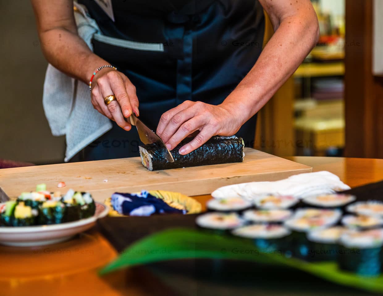 Vor dem Einrollen von Futo Maki Sushi wird die glänzende Seite des Algenblatts nach unten gelegt. Nach jedem Schnitt sollte das Messer mit einem feuchten Tuch gereinigt werden, damit alle Schnitte akkurat und sauber werden / © Foto: Georg Berg
