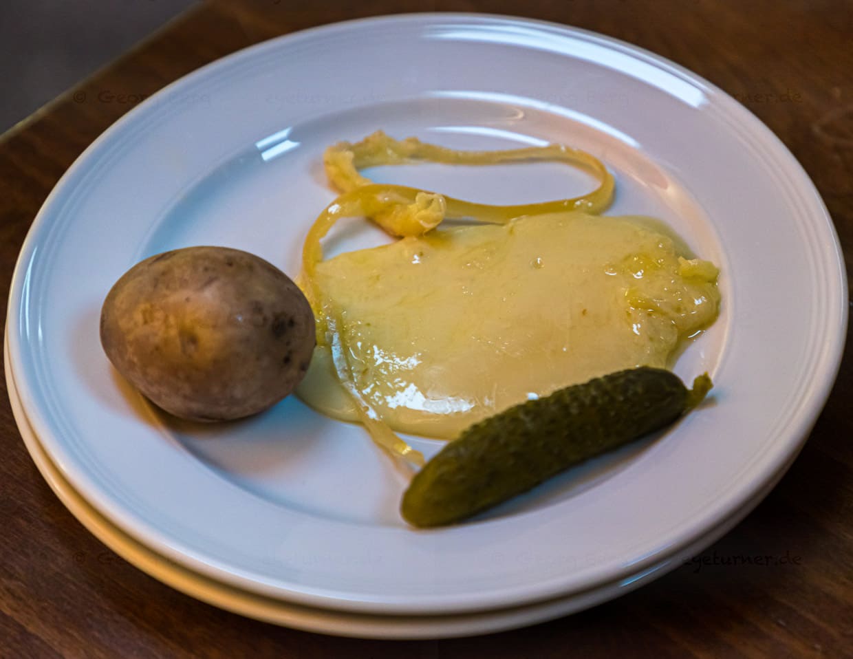 Pures Alpglück an Cornichon: Der Raclettekäse aus dem Wallis ist cremig und würzig. Er wird aus Rohmilch von Kühen, die auf Bergweiden stehen, hergestellt / © Foto: Georg Berg