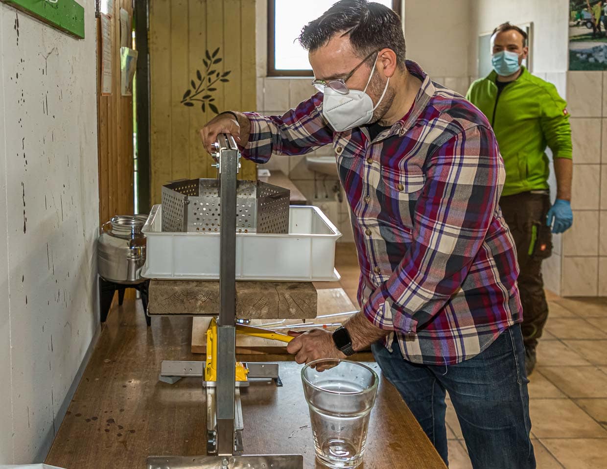 Olivenöl-Produzent Bastian Jordan an der Handpresse. Bastian Jordan richtet die Handpresse ein, aus der bis zum Ende des Tages dann 3,5 Liter Öl gewonnen werden / © Foto: Georg Berg
