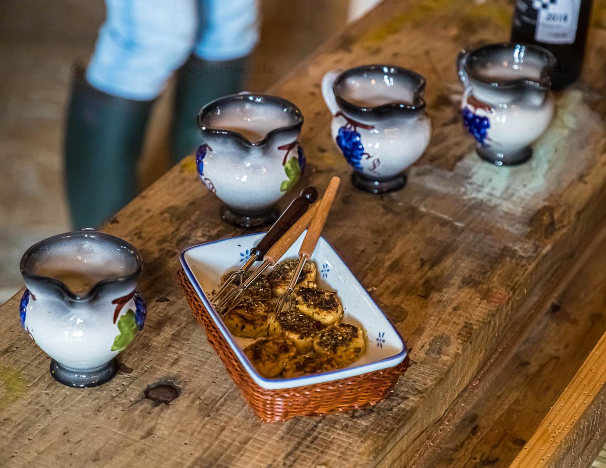 Zur Begrüßung gibt es kleine Fischfrikadellen und ein typisches Sommergetränk. Aus kleinen Keramikkrügen wird einfacher Weisswein gemischt mit Limonade serviert
