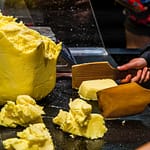 Die Butterstücke werden mit zwei Holzpaddeln geschlagen bis Wasser austritt. Die Butter beginnt zu weinen / © Foto: Georg Berg