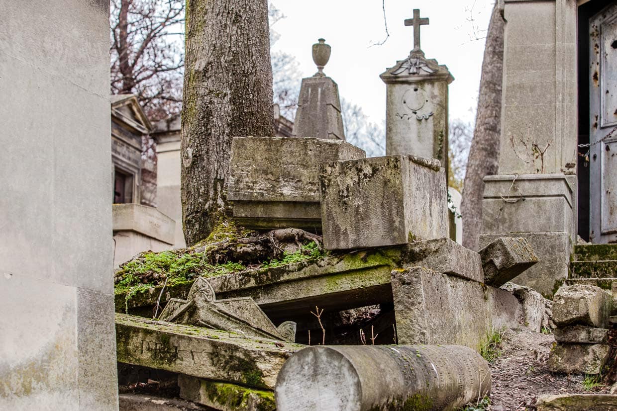 Grab mit von Baumwurzeln gesprengten Steinplatten auf dem Friedhof Père-Lachaise / © Foto: Georg Berg