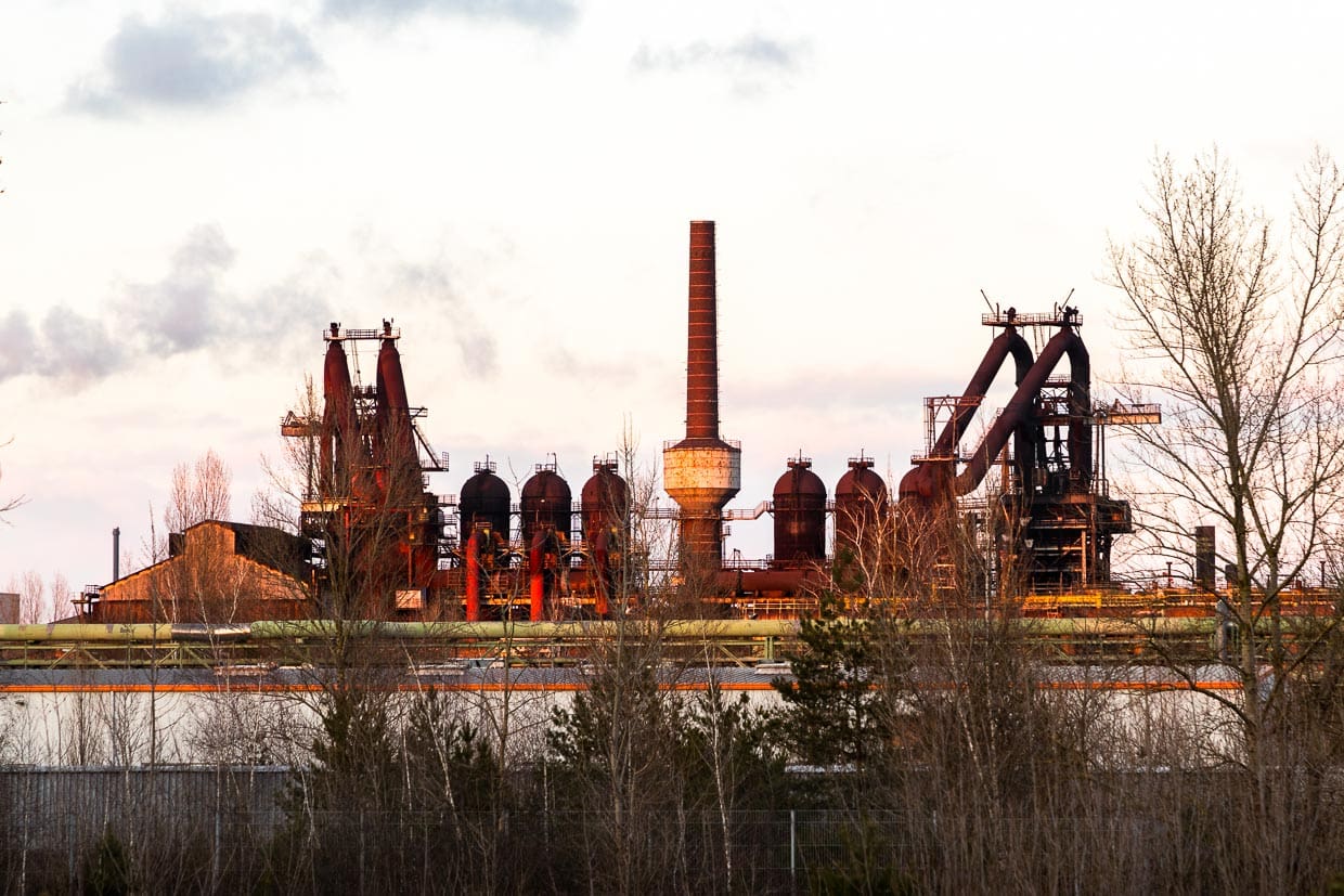 Eisenhüttenwerk in Eisenhüttenstadt (früher Stalinstadt). Die Planstadt hat keine Kirchtürme. Der Hochofen gehört zu den höchsten Bauwerken. Als zentraler Ort der Arbeit wurden Sichtachsen und Hauptstraßen bei der Planung Anfang 1950 zum Stahlwerk ausgerichtet / © Foto: Georg Berg