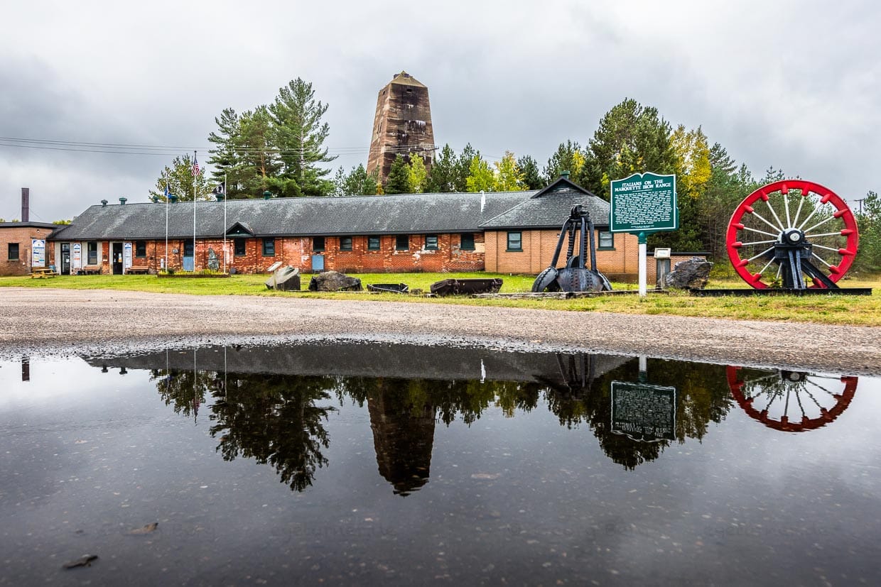 Das Cliffs Shaft Mine Museum im ehemaligen Trockengebäude, in dem sich die Bergleute umzogen, stellt die Bergbaugeschichte der Region dar. Im Hintergrund der 1967 stillgelegte Fördertum "A-Shaft" vom Architekten George Washington Maher in Form eines Obelisken in Form eines Obelisken entworfen / © Foto: Georg Berg