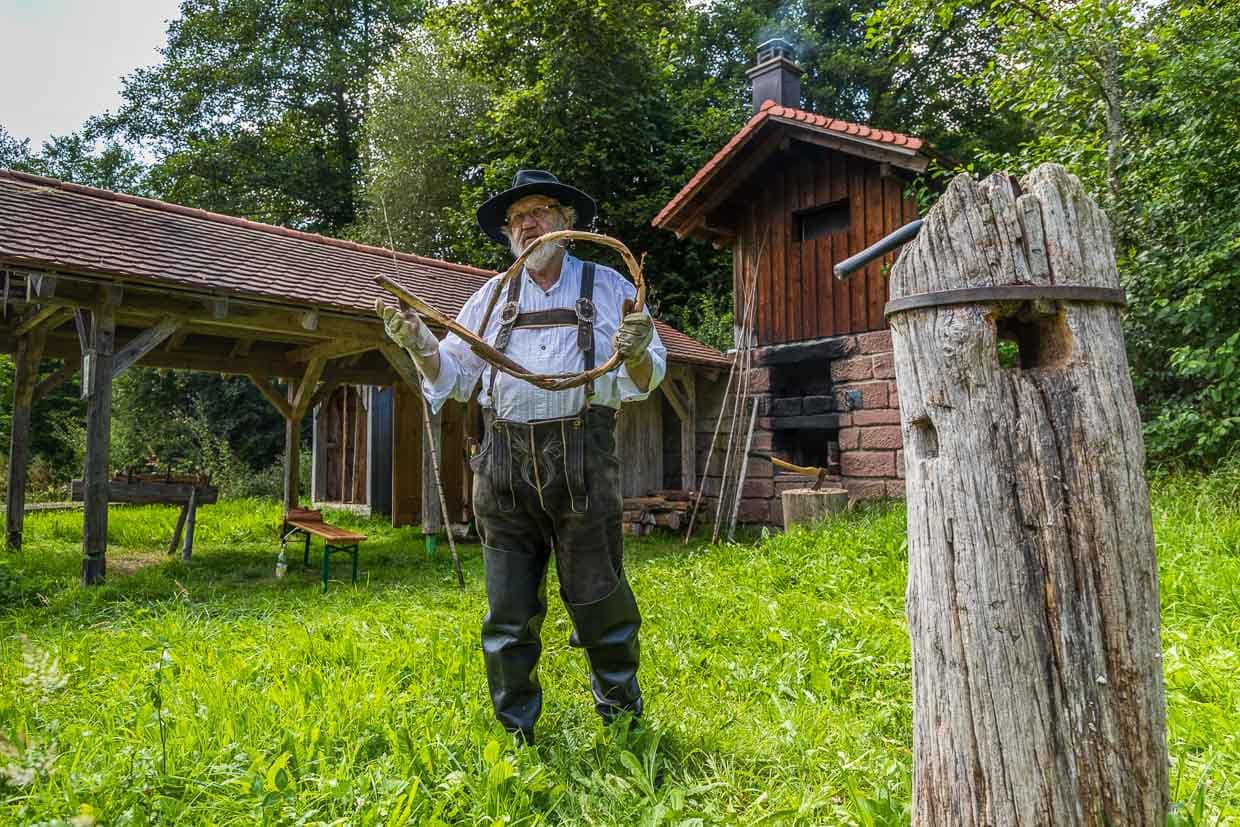 Flößer Martin Spreng beim Wiedendrehen. Das gedrehte Material, die Wiede, wird zu Ringen verschlungen und später zum Binden der Flöße verwendet. Für ein großes Floß werden oft mehrere hundert Wieden benötigt / © Foto: Georg Berg
