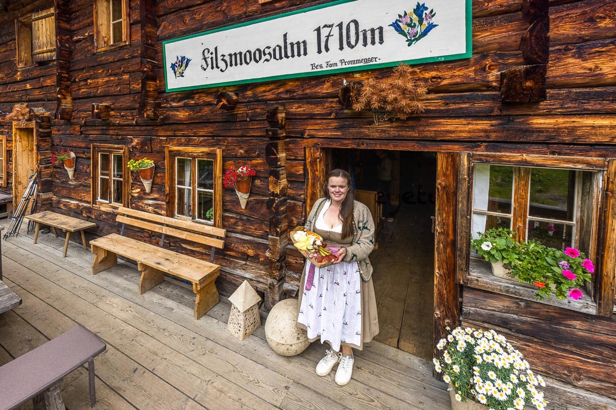 Paysanne, fromagère et alpagiste en une seule personne. Bettina Huber avec un plateau-repas à l'entrée de l'alpage de Filzmoos. Avec le lait de 10 vaches Pinzgauer, elle fabrique une grande variété de produits laitiers, dont du beurre, du babeurre, des yaourts, des boissons lactées, des fromages fermentés et des fromages à la coupe / © Photo : Georg Berg