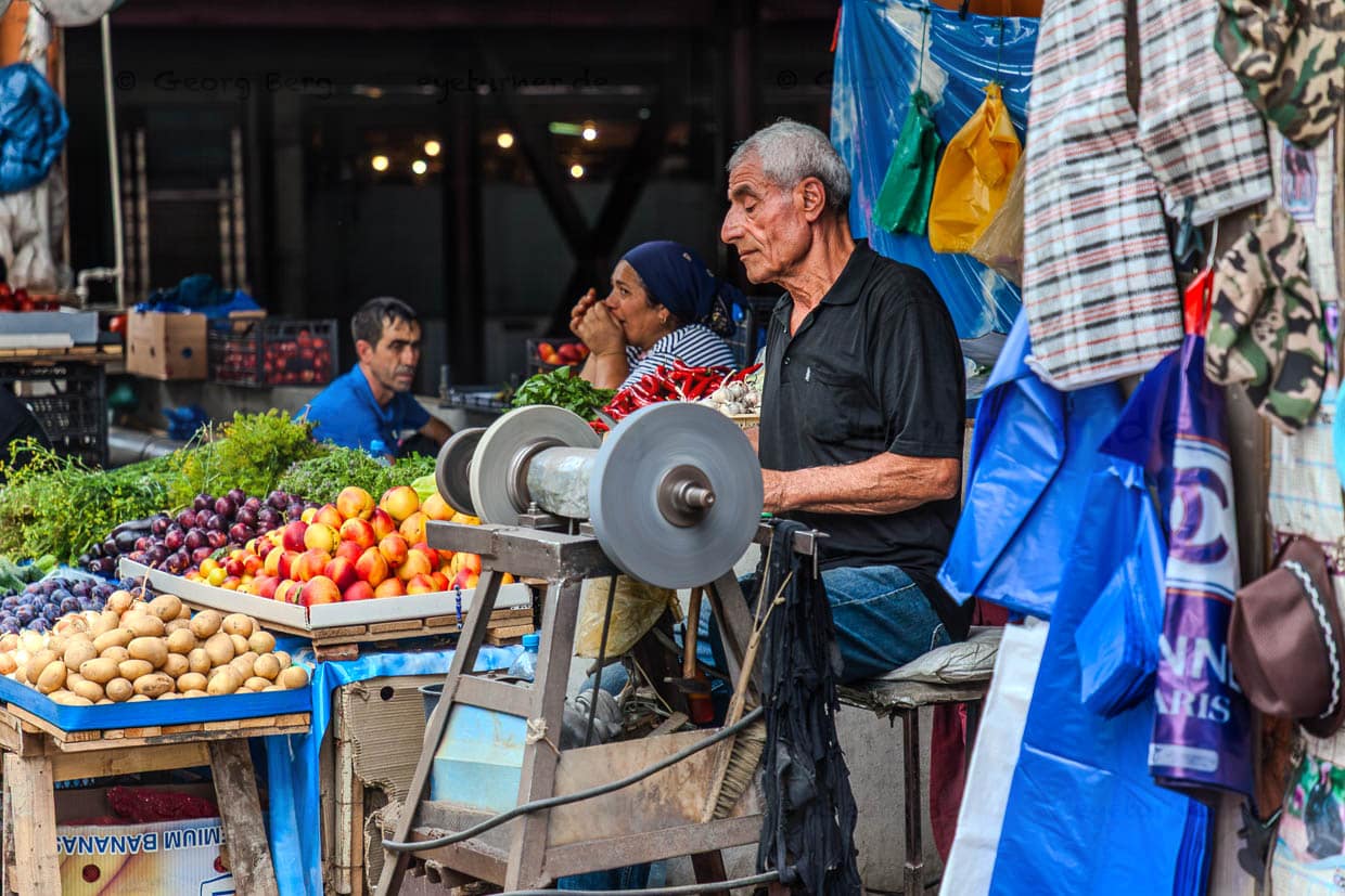 Un tailleur de ciseaux et un marchand de fruits au Dezerter Bazaar à Tiblisi. Le marché a reçu son nom dans les années 1920, lorsque les soldats déserteurs de la guerre Russie-Géorgie venaient y vendre leur équipement et leurs armes / © Photo : Georg Berg