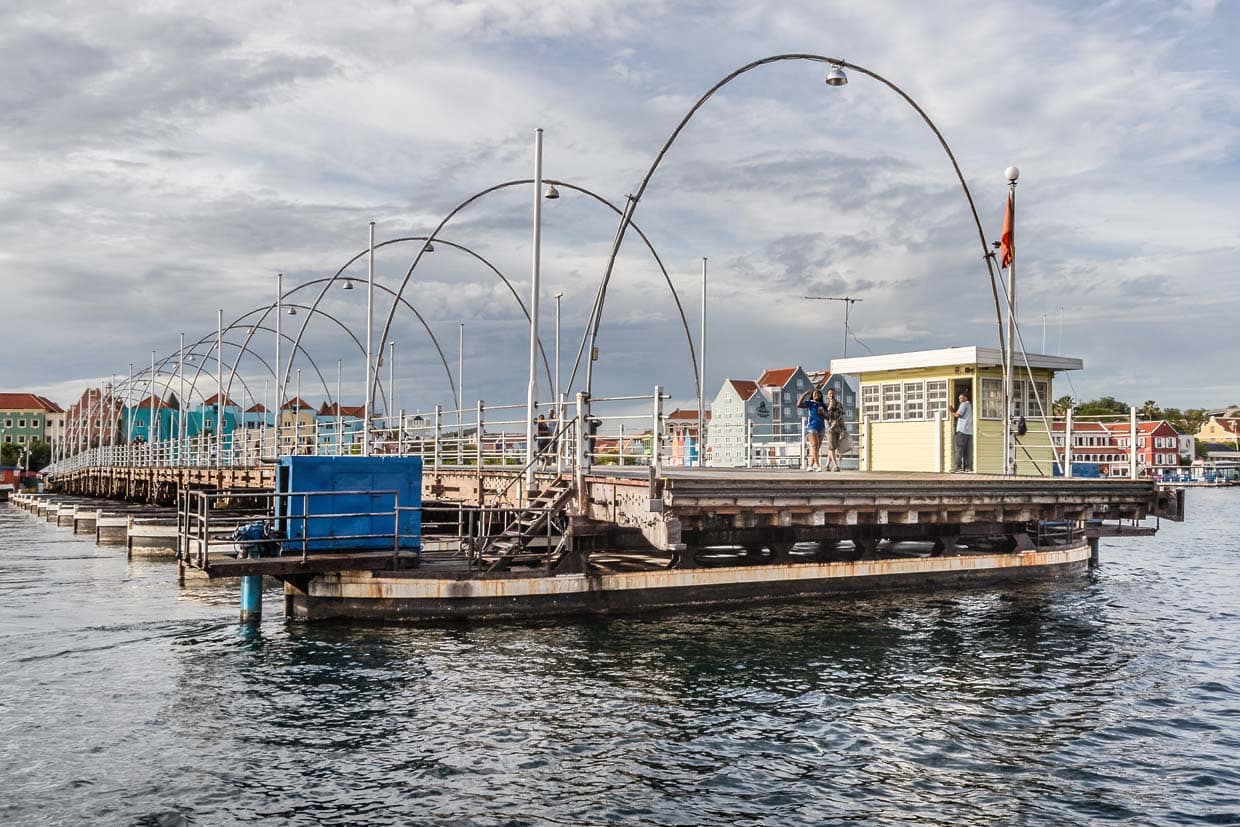 Le gardien de pont ouvre et ferme le pont Reine Emma avec un puissant moteur hors-bord. Les passants peuvent rester sur le pont pendant qu'il est ouvert aux bateaux / © Photo : Georg Berg