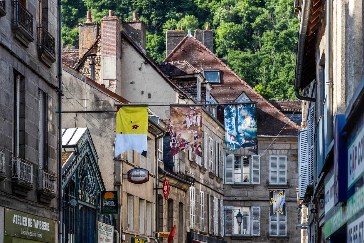 Hauptstraße von Aubousson mit Straßenschmuck, der an die Geschichte der Tapisserie in der Region erinnert. 2009 als immaterielles Kulturerbe der UNESCO anerkannt, verkörpert die Aubusson-Tapisserie eine über 600-jährige Tradition feiner Handwerkskunst und künstlerischen Designs, die bis heute gepflegt und weiterentwickelt wird / © Foto: Georg Berg