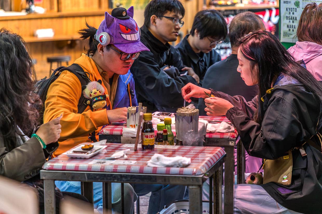 Grinsende Cap auf dem Kopf und ein Pokemon am Rucksack: Nuigurumi Charms heißt der Trend, bei dem Plüschtiere aller Art am Rücksack, an der Kleidung oder als Cap getragen werden / © Foto: Georg Berg