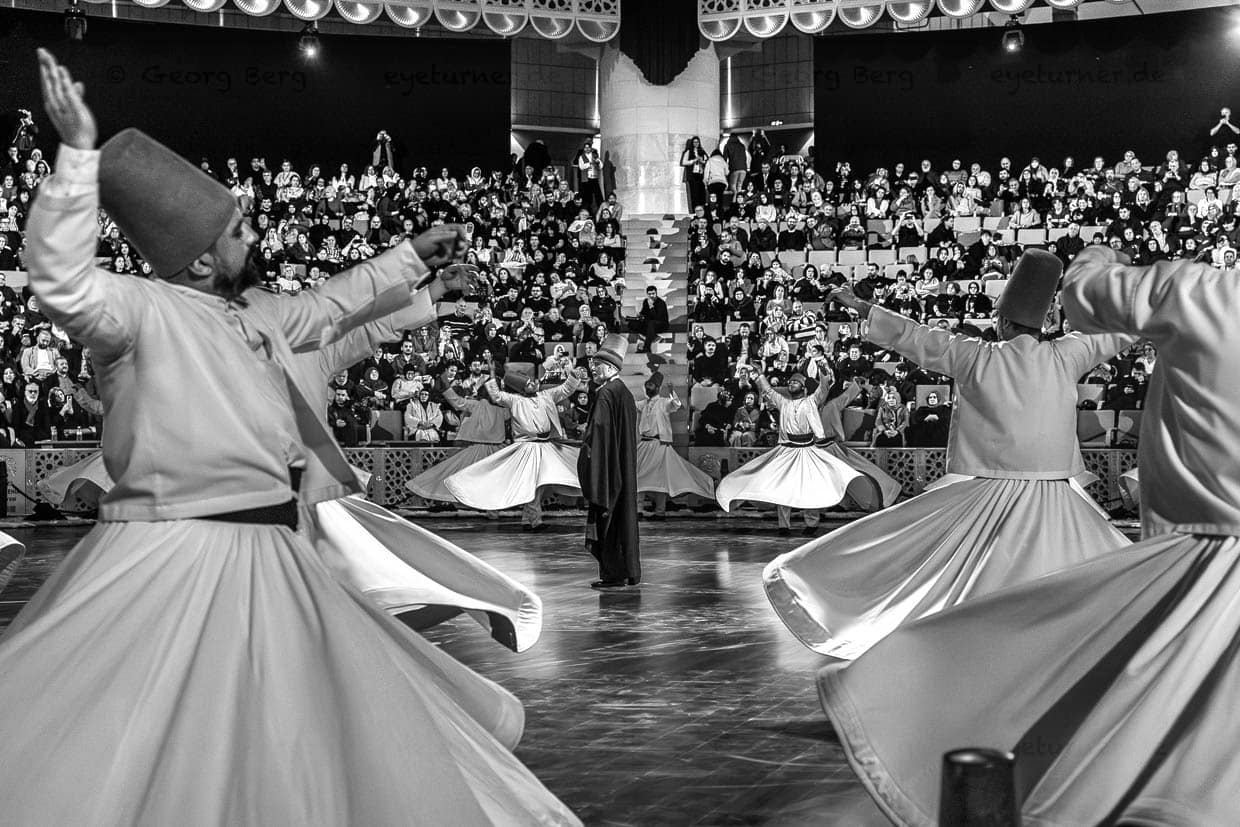 Zwischen den Tänzern bleibt der Gözcü für die Zuschauer meist unsichtbar. Er gibt Derwischen, denen schwindelig wird, Orientierung / © Foto: Georg Berg