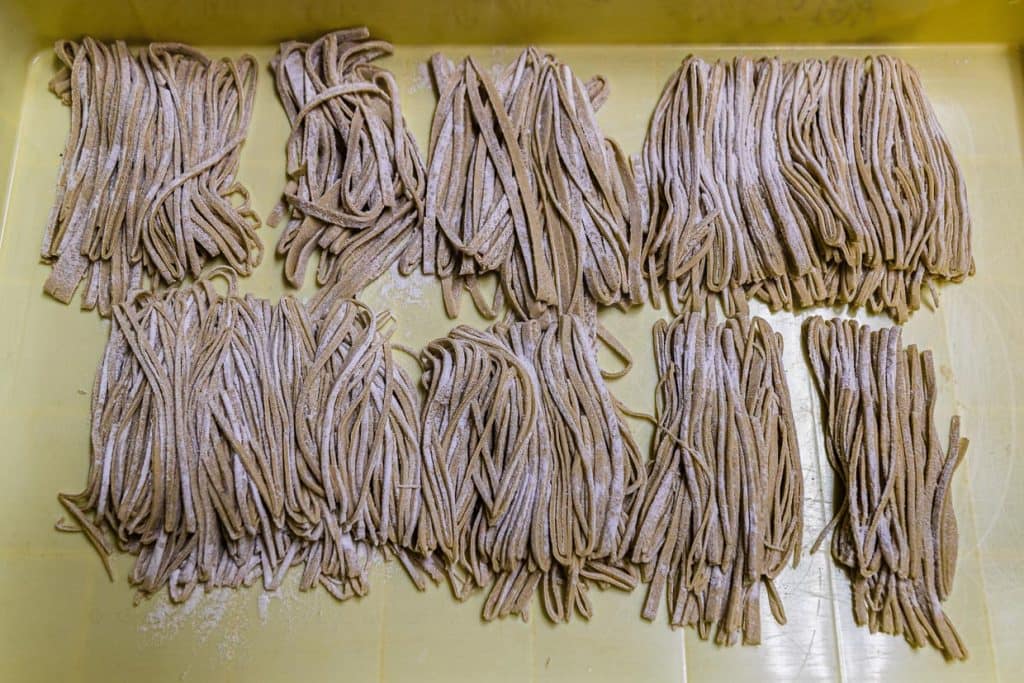 Sobanudeln bereit für den Kochtopf. Dass hier auch eine ungelernte Kraft am Werk war, sieht man an den zum Teil viel zu dicken Streifen / © Foto: Georg Berg