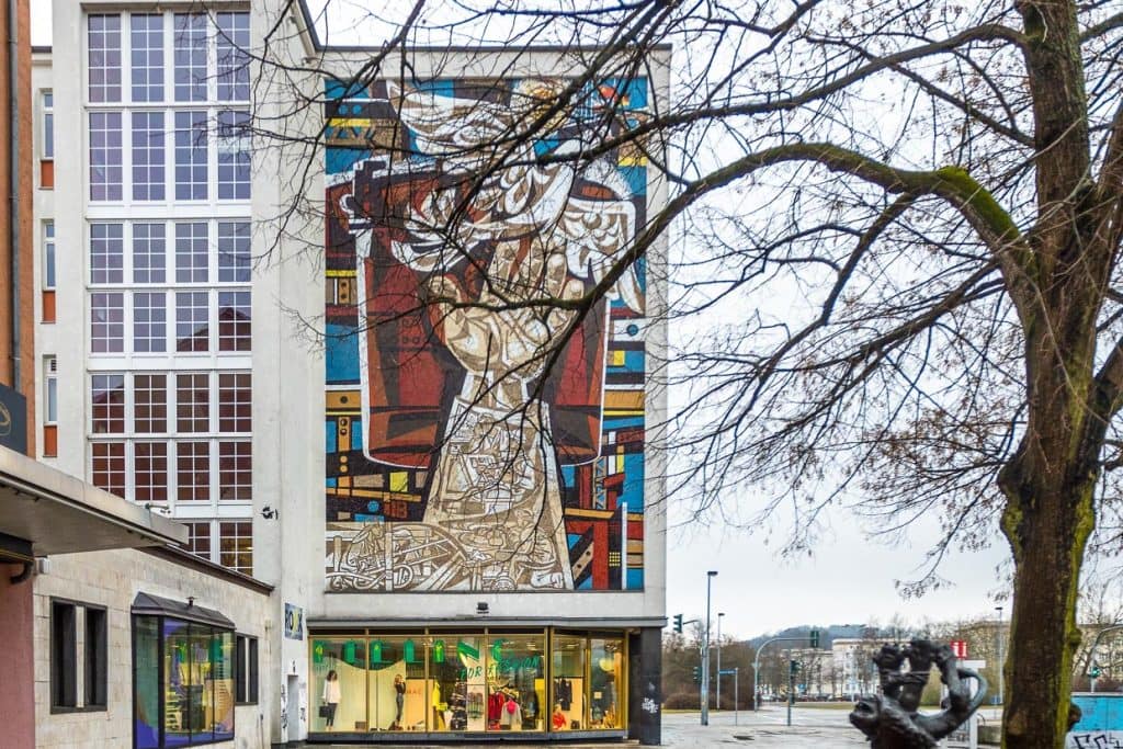 Kaufhaus in der Lindenallee, Eisenhüttenstadt mit Mosaik von Walter Womacka, Arbeit für den Frieden von 1960. Die starke Hand des Arbeiters schafft Frieden. Idealisierung der sozialistischen Lebensweise / © Foto: Georg Berg