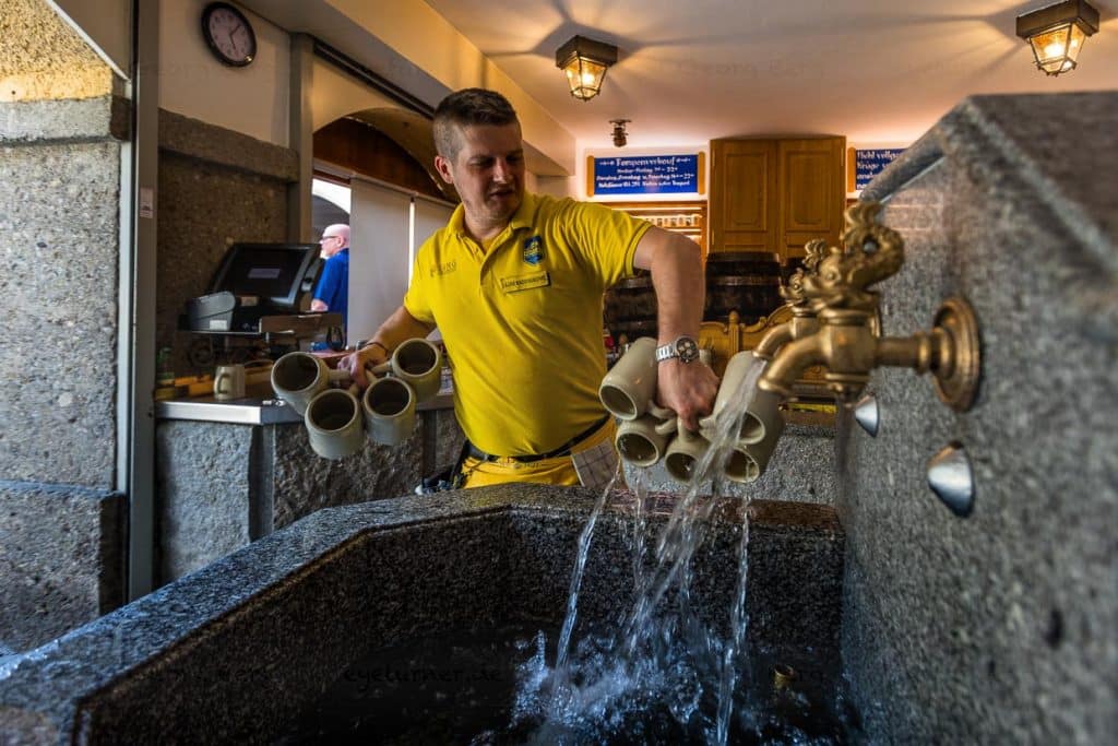 Bierausschank im Augustiner-Bräu, Kloster Mülln. Das Bier wird in traditionellen Steinkrügen ausgeschenkt. Der Steinkrug wird vorab mit kalten Wasser ausgespült. Die Brauerei verfügt über ein eigenes Wasserkraftwerk / © Foto: Georg Berg