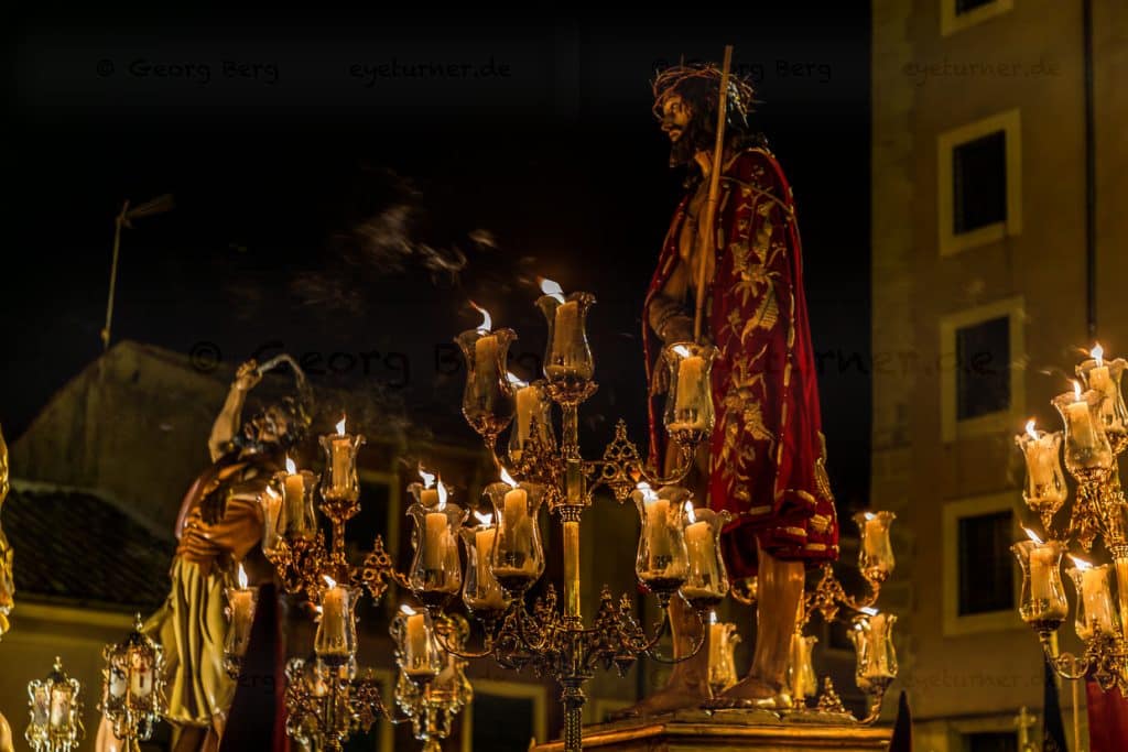 Procesión en España con la figura de Jesús y muchas velas encendidas. / © Foto: Georg Berg