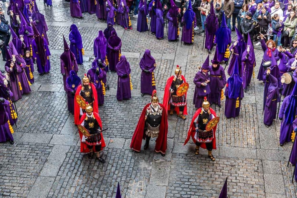 Participantes con túnicas moradas y uniformes romanos en la Procesión Camino del Calvario / © Foto: Georg Berg