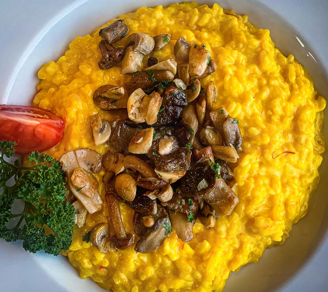 Im Safran-Pilz-Risotto sind noch einige der roten Safran-Fäden zu erkennen / © Foto: Georg Berg