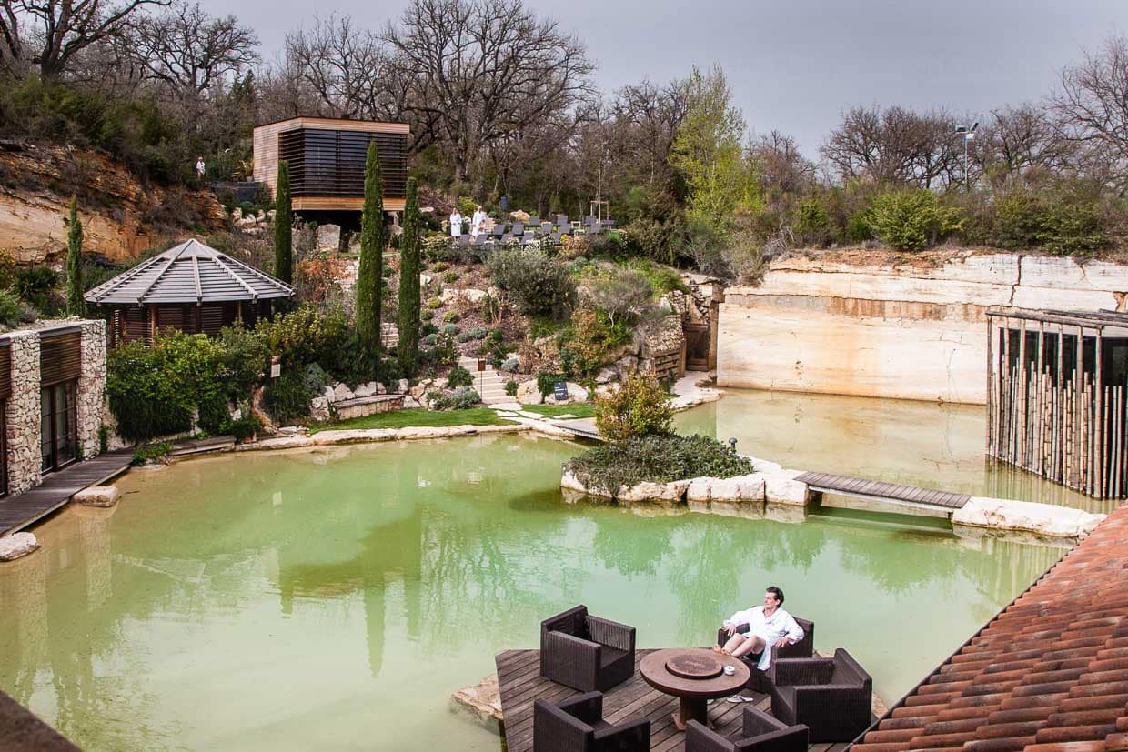 Eine der vielen kleinen Oasen auf dem Gelände des Hotels Adler Thermae. Hier sieht man besonders gut, dass die Anlage in den aufgelassenen Steinbruch gebaut wurde. Die Wand im Hintergrund des Sauna-Gartens ist Travertin-Gestein, das sich auch im Hotel selber oft wiederfindet / © Foto: Georg Berg