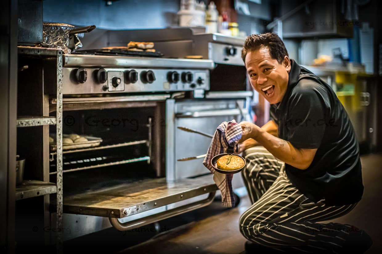 Der gut gelaunte Koch heißt Madé, stammt aus aus Bali und ist seit Jahren Küchenchef der Bamuru Plains Lodge und für viele der gut betuchten Gäste ein guter Grund, hier her zu kommen. Manch einer hat ihn schon für eigene Festlichkeiten gebucht / © Foto: Georg Berg