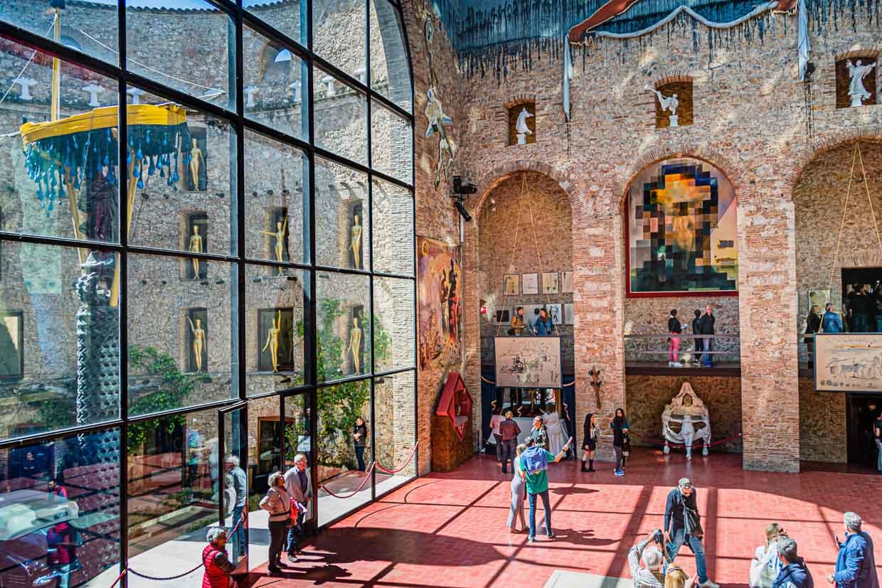 Das alte Theater gestaltet Salvador Dali zu seinen Lebzeiten in ein Museum. Er ordnete seine Beisetzung im Zentrum der ehemaligen Theaterbühne an. Heute spazieren die Besucher über den roten Steinboden und entdecken eher zufällig die Bodenplatte an Dalis Grab / © Foto: Georg Berg