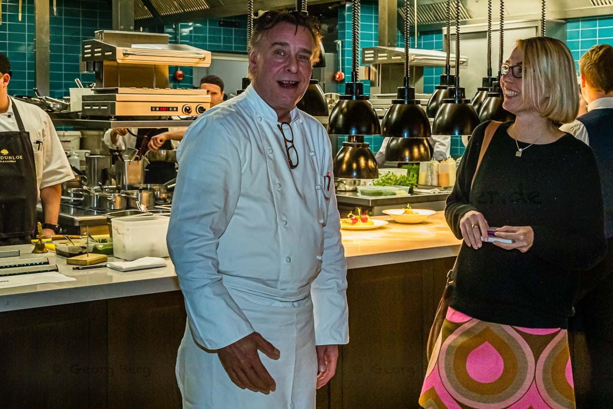 Chefkoch Jupp Osterloh vor der neuen offenen Küche im Restaurant The Grill im Gespräch mit Angela Berg / © Foto: Georg Berg