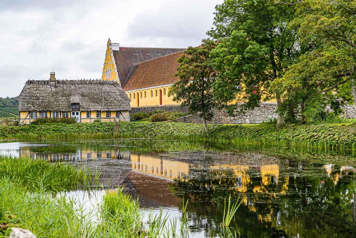 Entlang der Landstraßen kommt man auf Fyn an vielen malerischen Gutshäusern vorbei, die oft in kräftigen Farben gegen den blauen Himmel strahlen / © Foto: Georg Berg