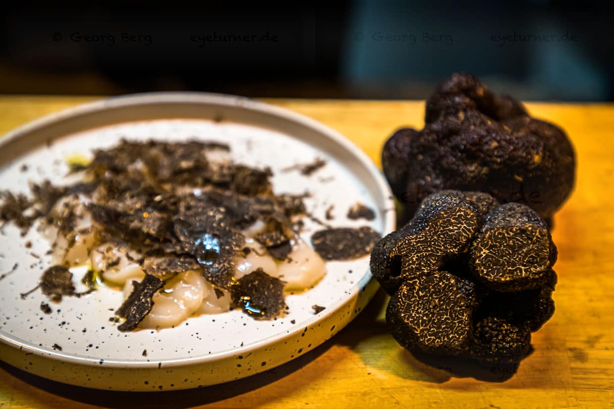 Jakobsmuschel mit Trüffel, hier wurden die Scallops in dünne Scheiben geschnitten und mit Olivenöl, Meersalz, schwarzem Pfeffer und Trüffel gewürzt / © Foto: Georg Berg