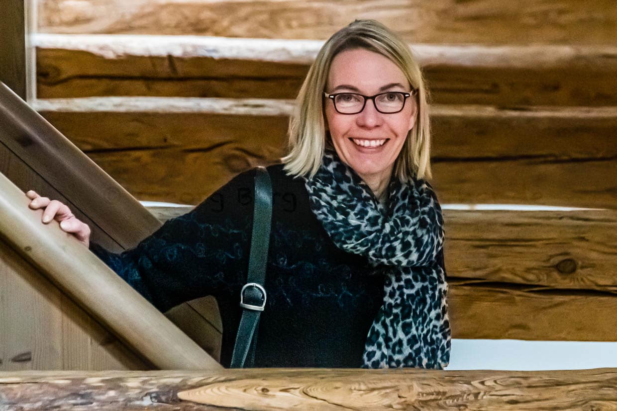 Angela Berg mitten im Gebälk. In vielen Räumen sind die alten Holzbalken offengelegt, werden in Kontrast zu modernen Möbeln gesetzt / © Foto: Georg Berg